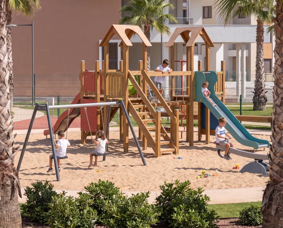 Área infantil con columpios y tobogán