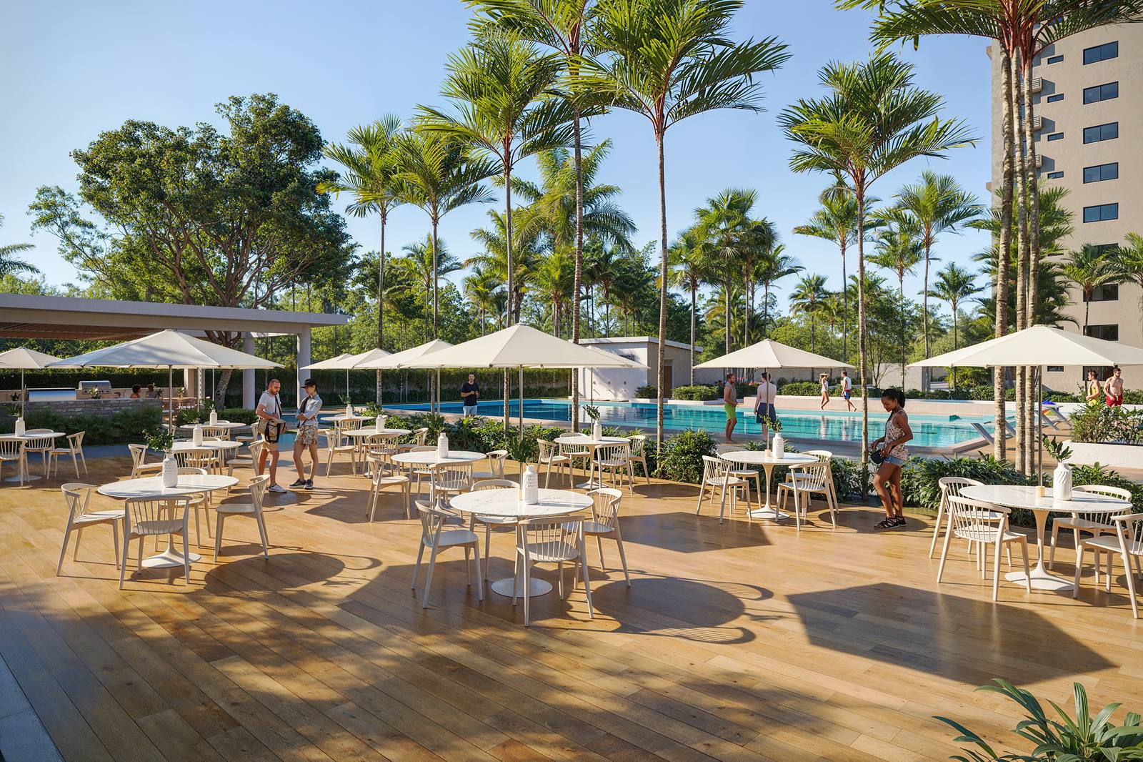 Terraza de la piscina de Brisas 6 con mesas, sombrillas y palmeras